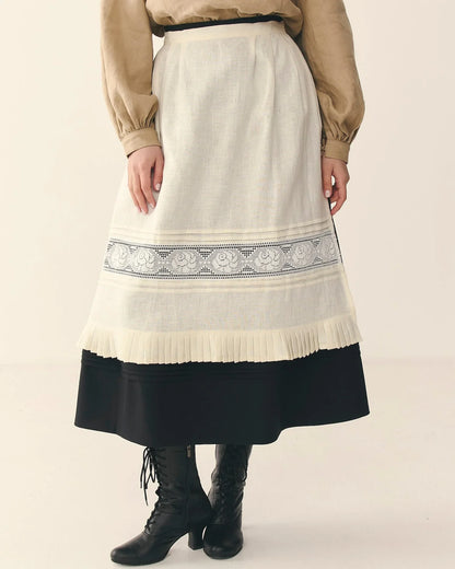 Traditional Ukrainian embroidered apron with pleated hem and lace details over long skirt